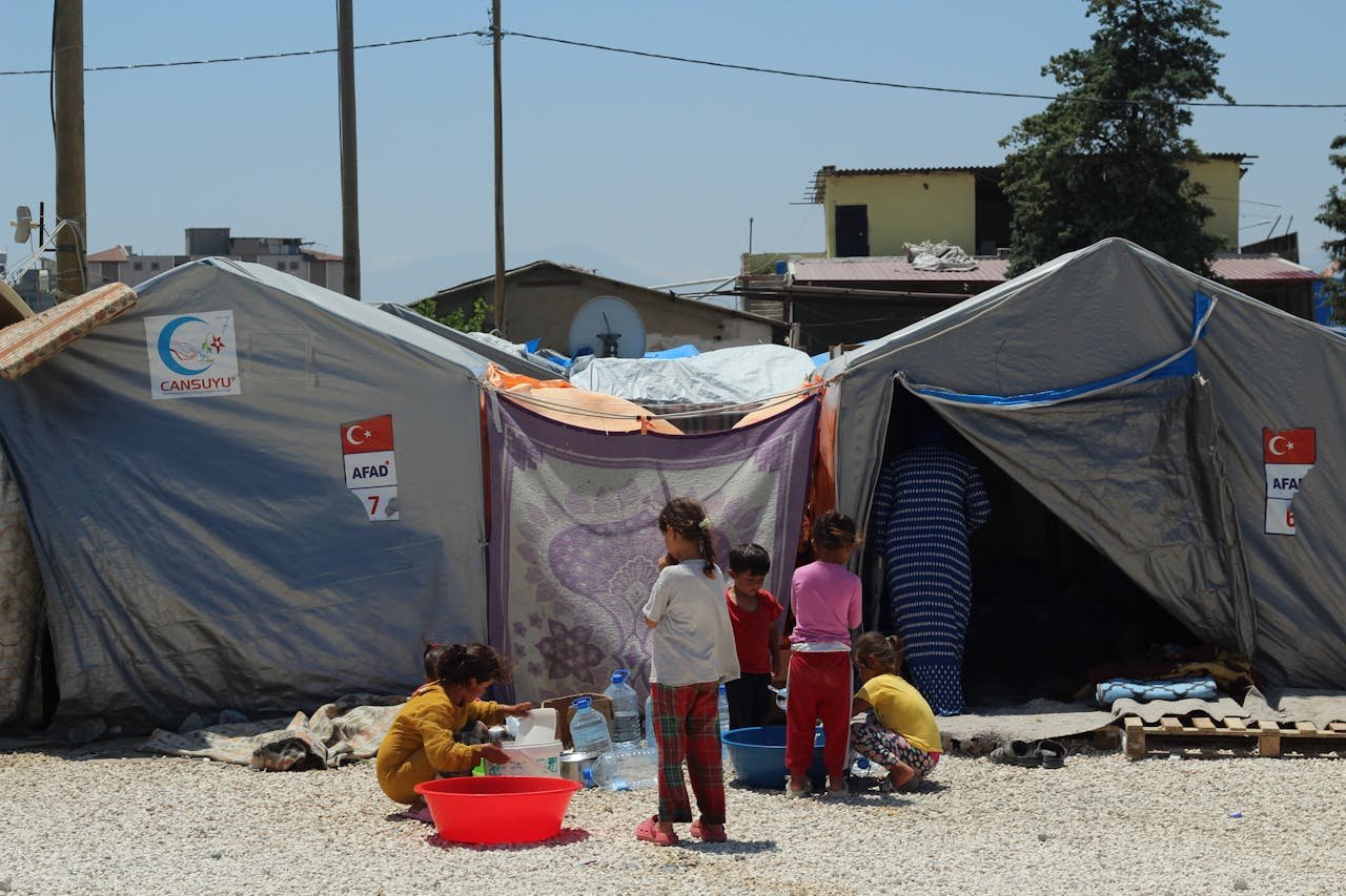 impact-img Group of children at a temporary tent camp highlighting post-disaster resilience.