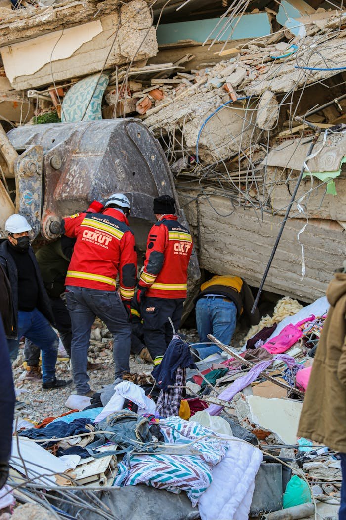 Mastering the First Impression: Your intriguing post title goes here Rescue workers in red uniforms search through the rubble of a collapsed building after an earthquake.