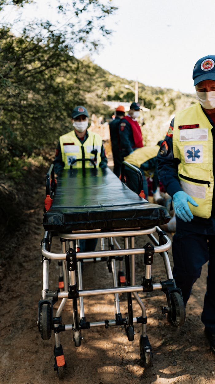 Emergency responders navigate outdoors with a stretcher during a simulation exercise.